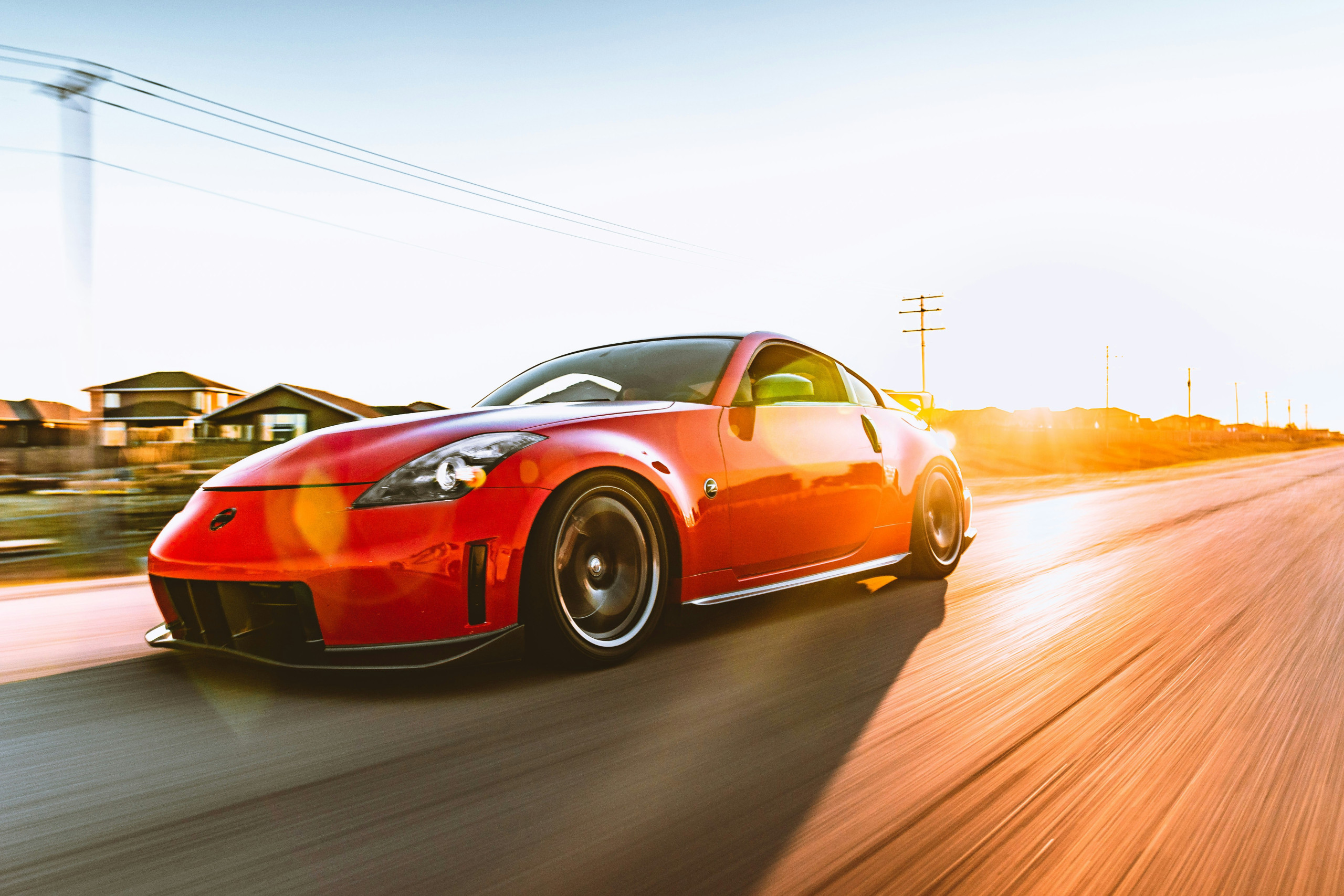 Red car driving in sunshine